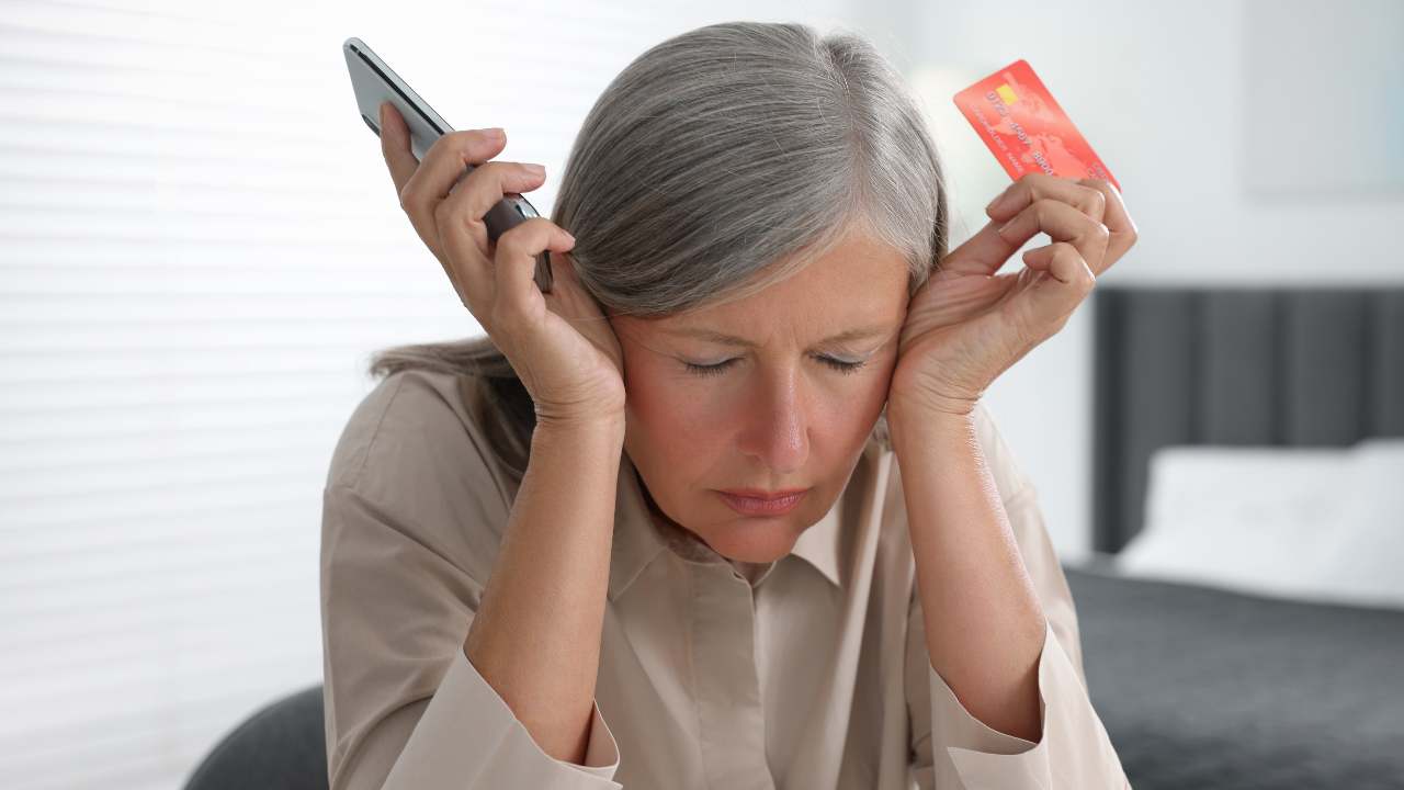 upset woman with phone and gift card in hand