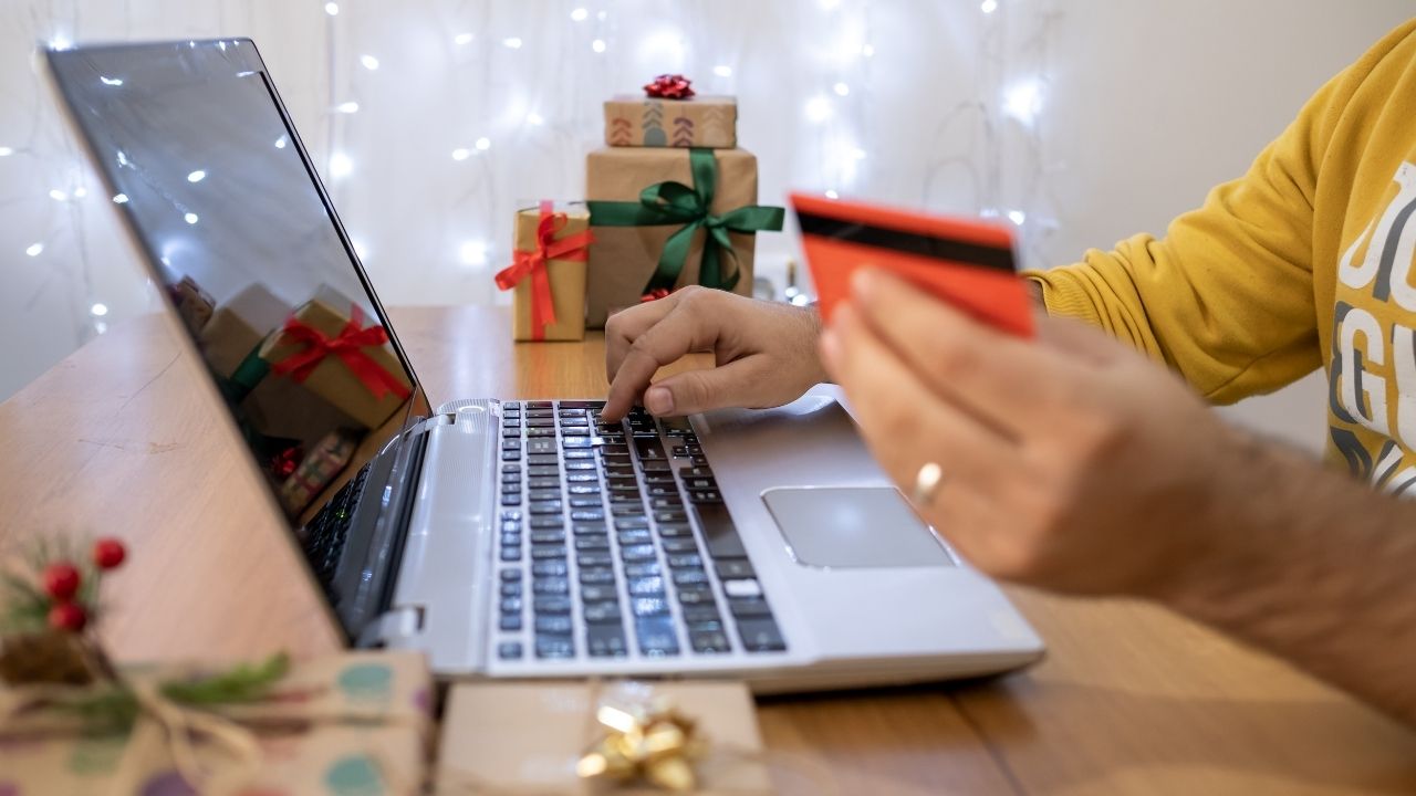 person typing a plastic gift card into a computer