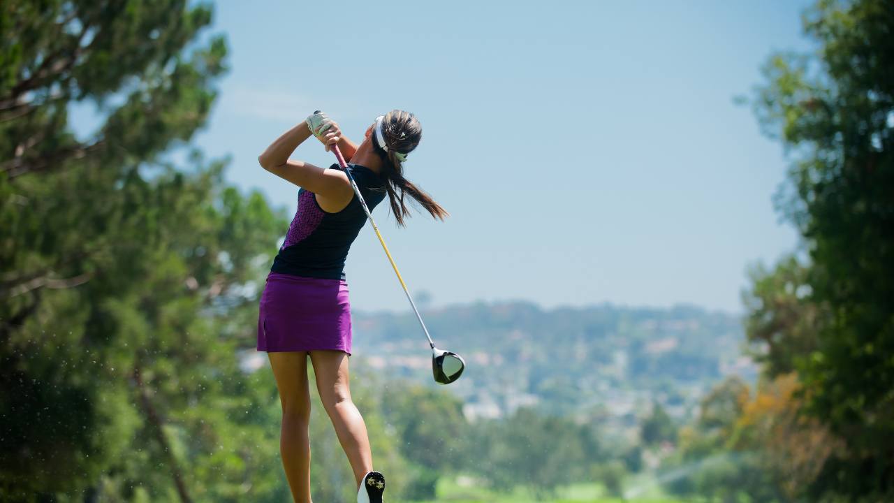 woman hitting a golf ball